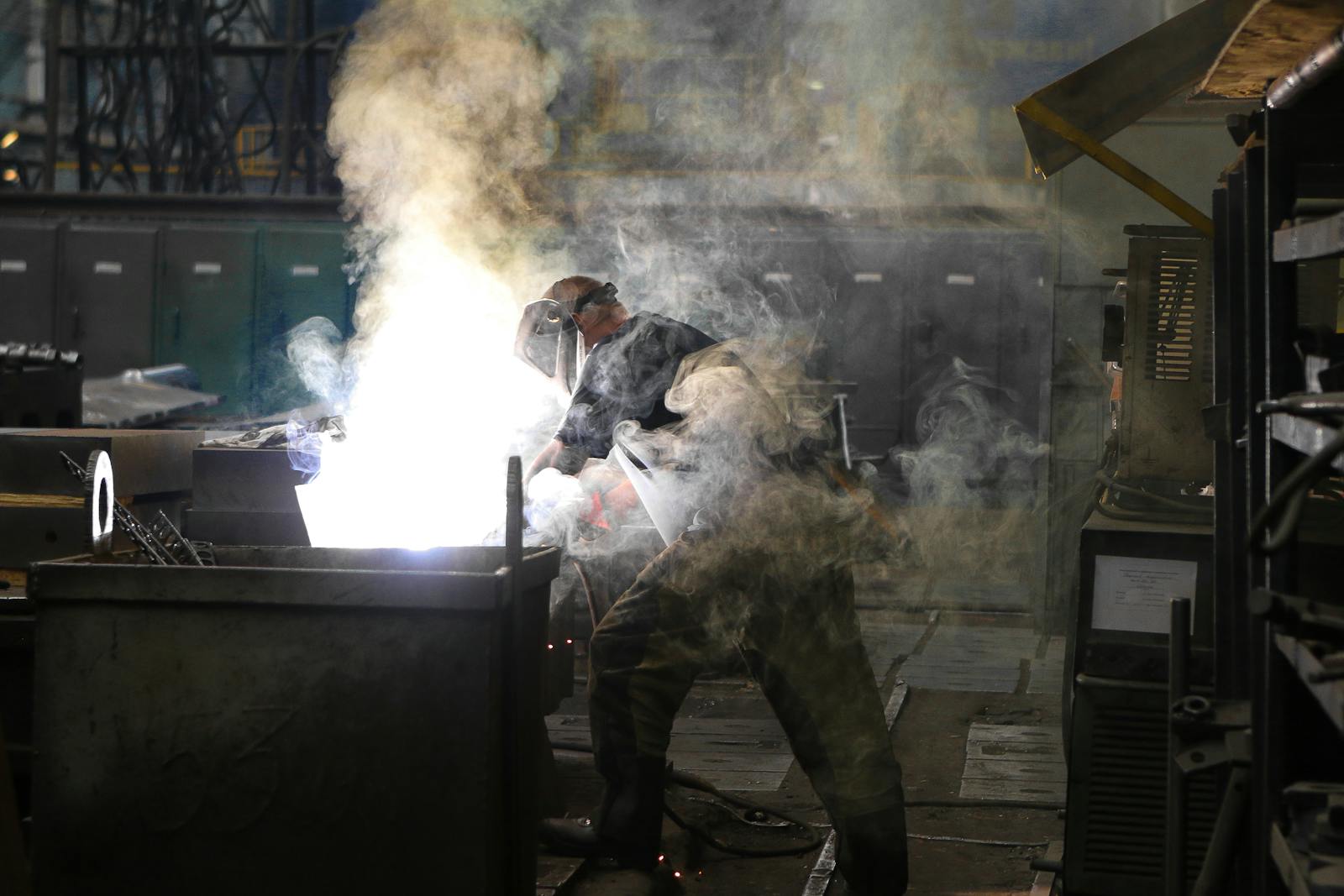 Man Wearing Welding Mask Covered in Welding Smokes