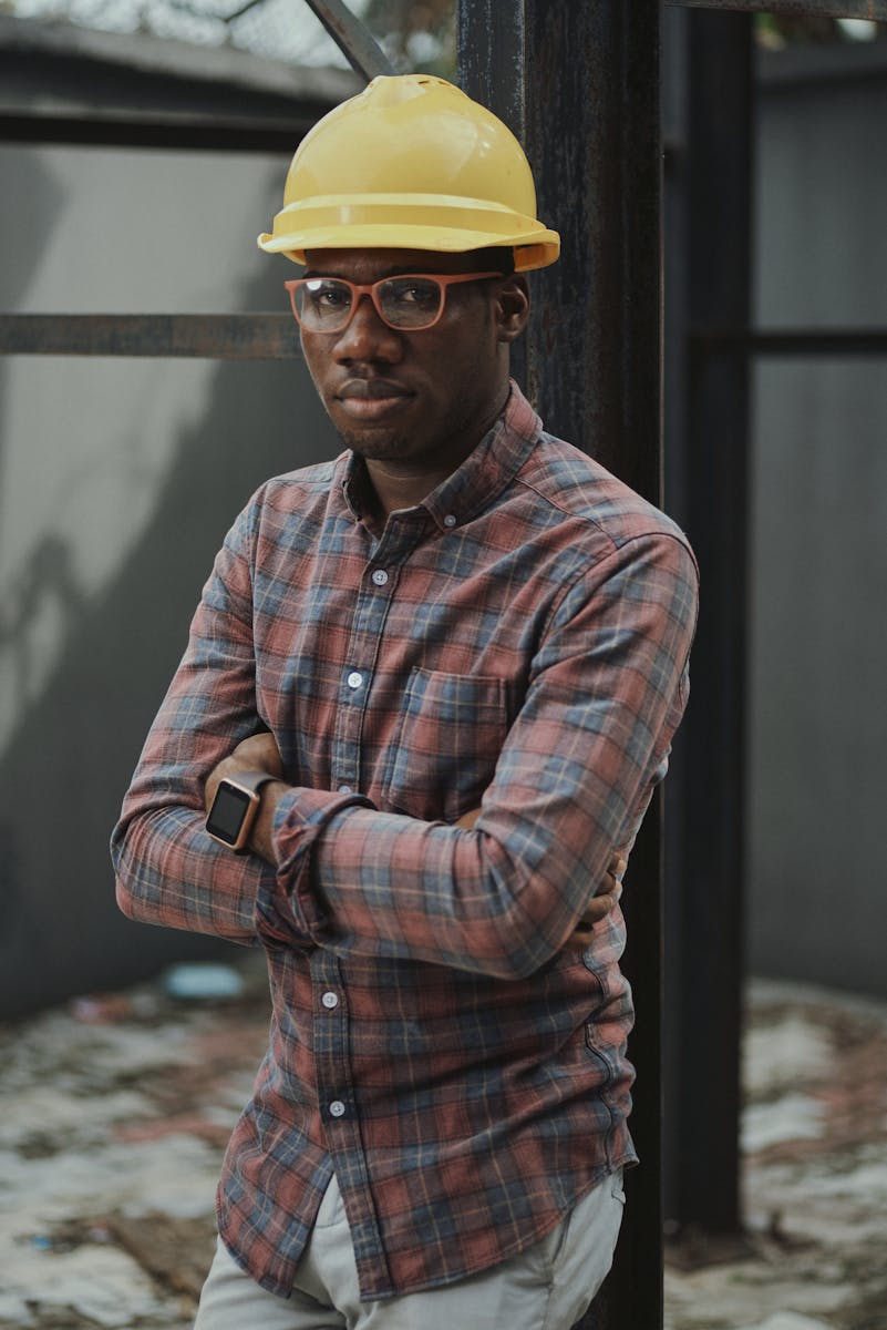 Man in Plaid Shirt Wearing Hard Hat while Looking at Camera