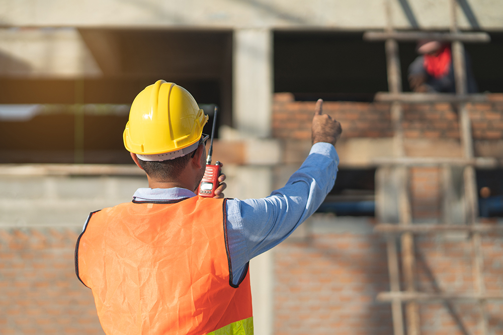 Asian inspector checking structure of new property and taking note in the clipboard for review and fix the house before sell to client