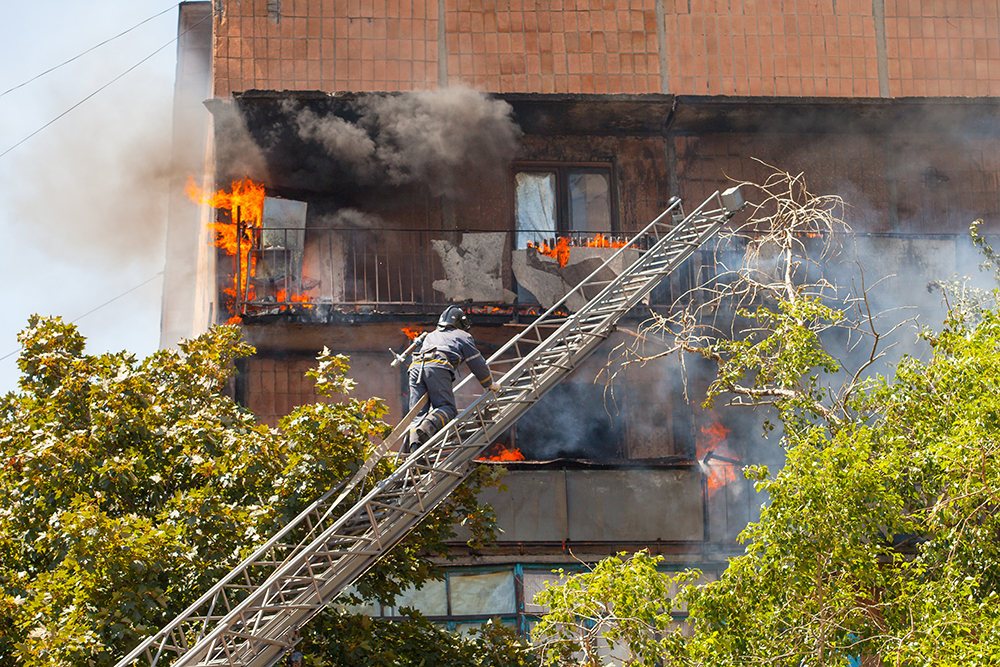 firefighters extinguish a fire in a high-rise residential building