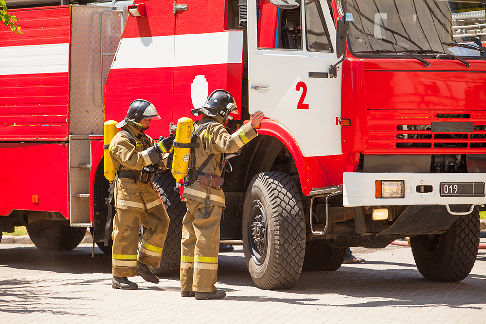 firefighters extinguish a fire in a high-rise residential building