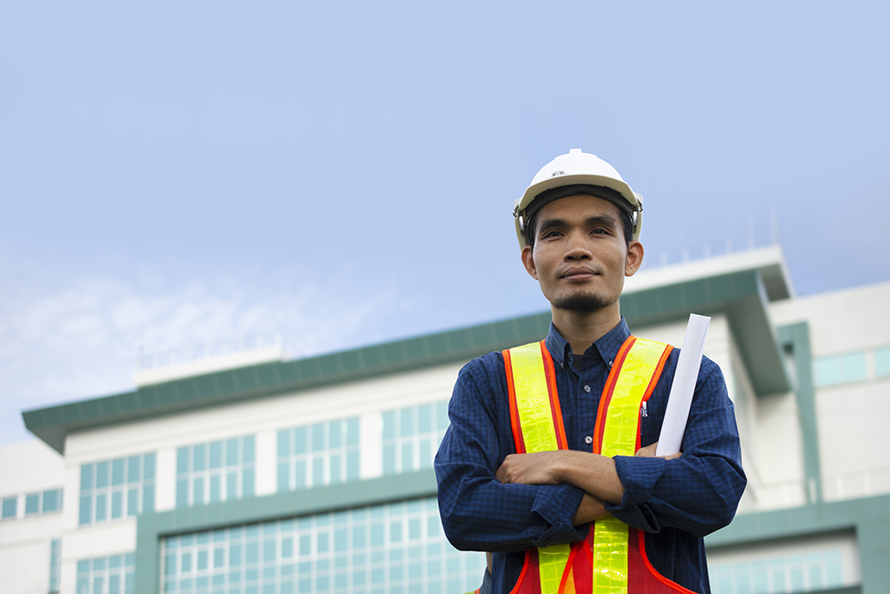 Engineering wears a white safety hat while working. Background building structure