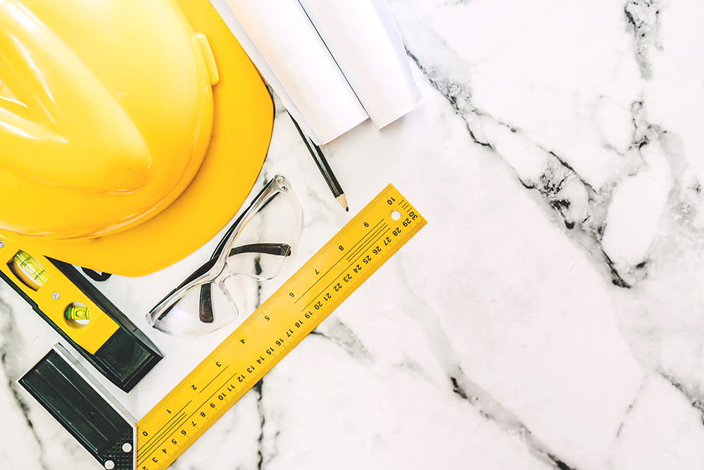 Construction tools with helmet safety on white marble background